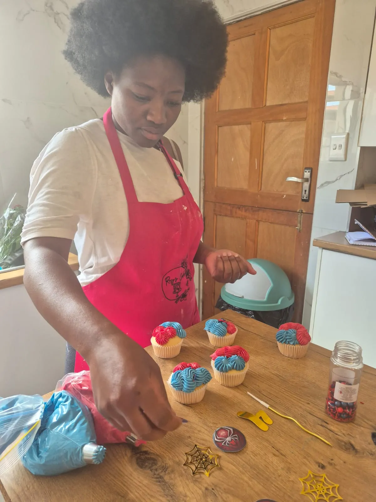 A Rosy's Cakes and Events trainee piping buttercream onto cupcakes