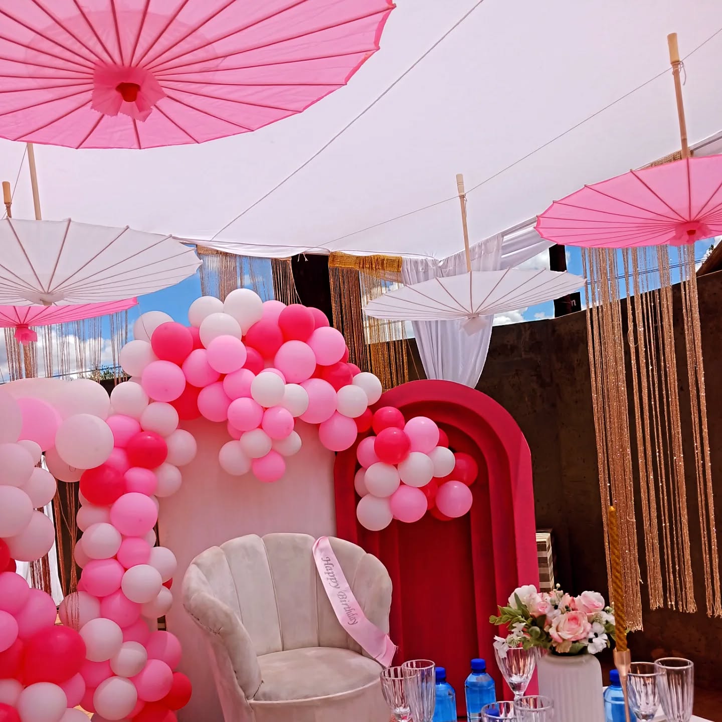 A pink and white party backdrop styled by Rosy's Cakes and Events